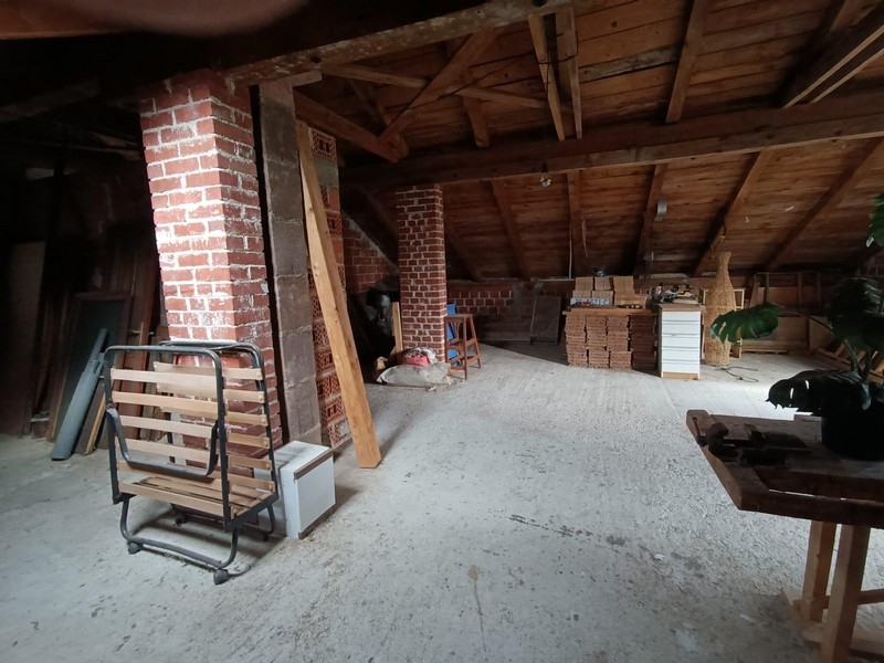 Vindsrum med synliga träbjälkar och tegel i hyreshus till salu i Crikvenica, Kroatien.