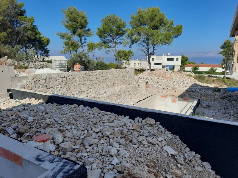 Byggarbeten på en modern villa till salu på ön Brač, Kroatien, med utsikt över havet.