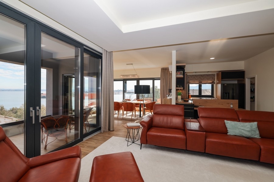 Vardagsrum med L-formad skinnsoffa och öppen övergång till köket i villa på Ugljan som är till salu