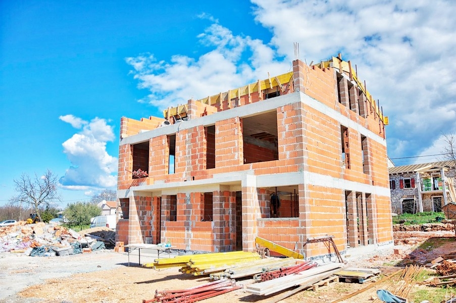 Skal av parhuset i byggskede med tegel och ställningar