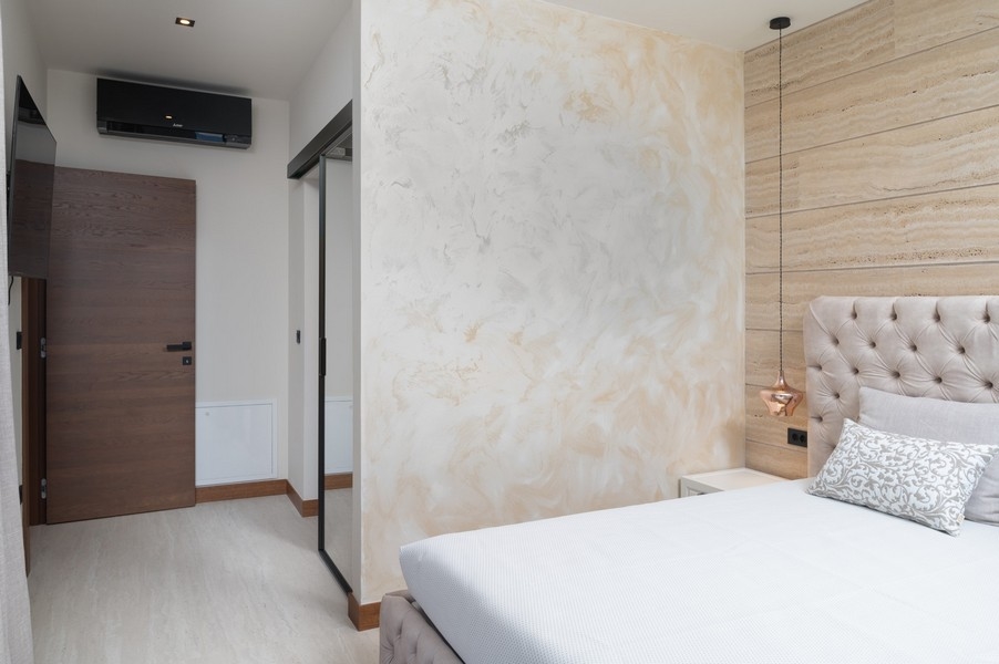 Modernt designat sovrum med stoppad sänggavel i en villa till salu i Razanac, Zadar-regionen, Kroatien, med skjutdörr till korridoren