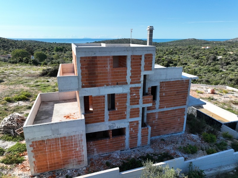 Framifrån av en modern villa med havsutsikt i Kroatien, poolområde i skymningen