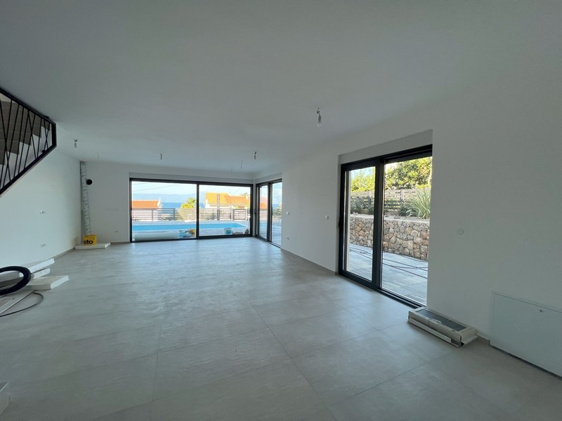 Vardagsrum med fri utsikt utanför och öppen trappa, kännetecknande för moderna fastigheter i Kroatien.