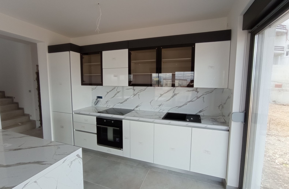 Interiörvy av ett modernt kök med vita möbler i en fastighet i Kroatien.