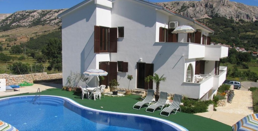 Hus med pool, gräsmatta och parasoll