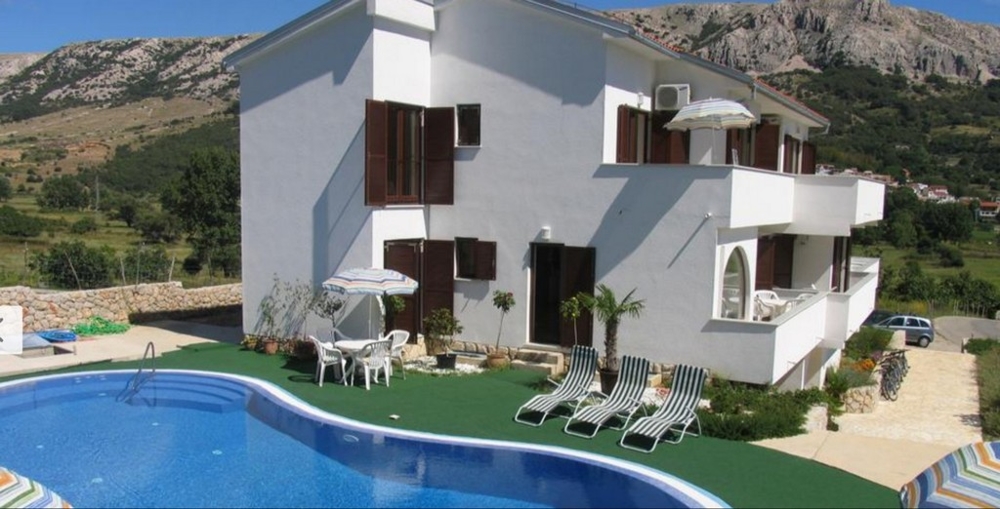 Sommarhus i Kroatien med blå pool och solstolar framför bergslandskapet, Kroatiens fastigheter