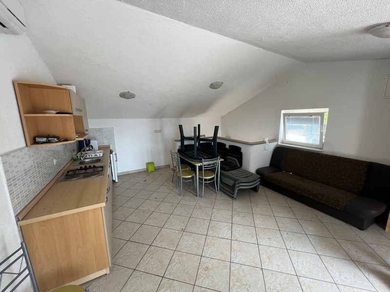 Rymligt, vindsliknande vardagsrum med kökshörna, del av en fastighet på ön Krk.