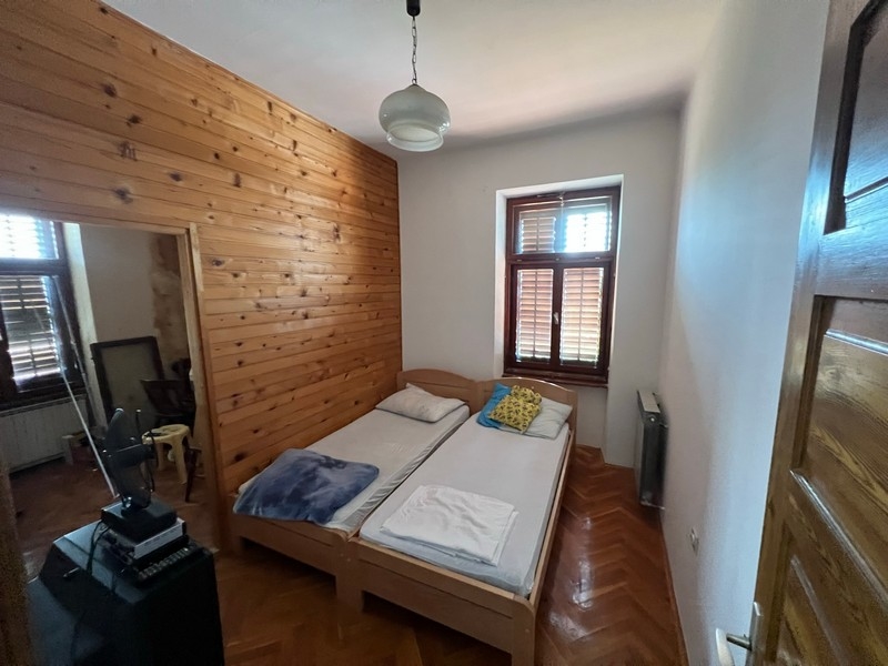 Mysigt sovrum med träväggar och två enkelsängar i en fastighet på ön Krk.