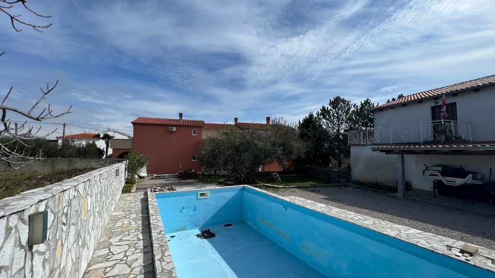 Fastigheter Kroatien, staden Krk, ön Krk Köpa ett hyreshus, bakifrån av huset med tom pool och trädgård