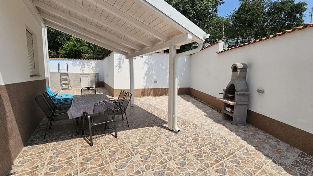 Vardagsrum med soffa, matbord och tillgång till altan i ett parhus