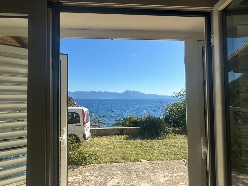 Ljusorange kök med matbord och moderna apparater i en villa vid havet på halvön Pelješac