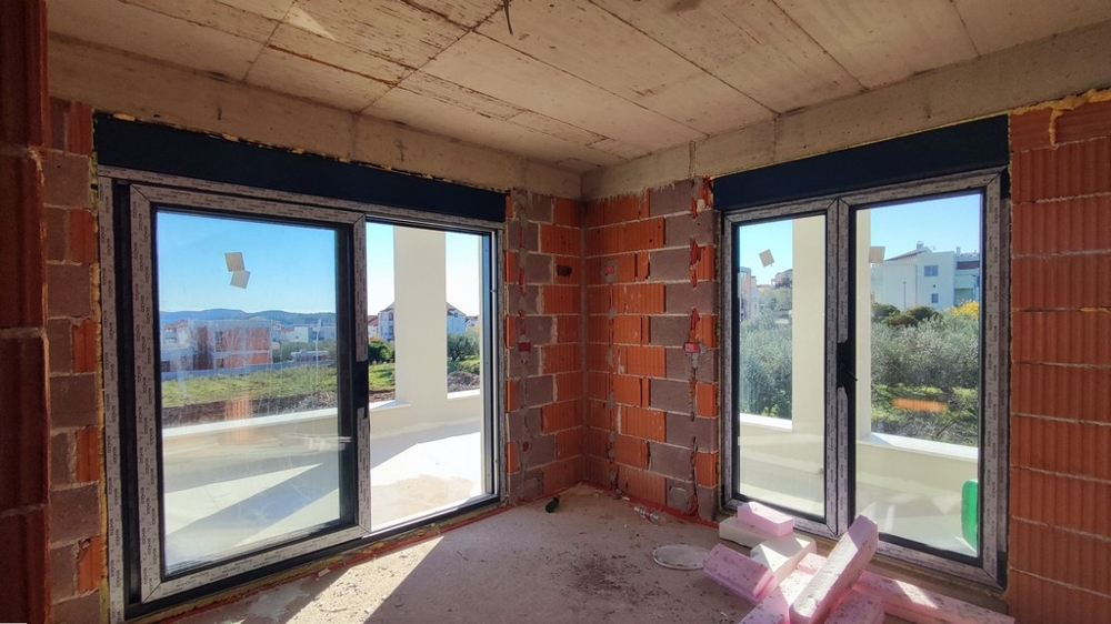 Vardagsrum med utsikt över terrass.