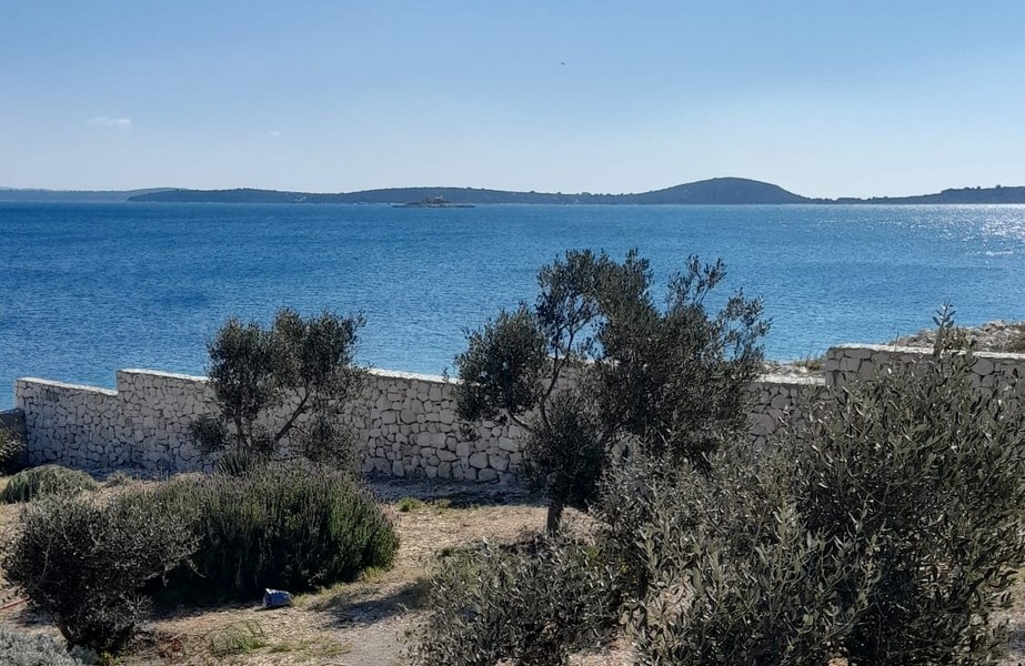 Fastigheter Kroatien, hus precis vid havet - Panorama Scouting H3015: Utsikt över havet från en täckt terrass med solstolar och parasoll.