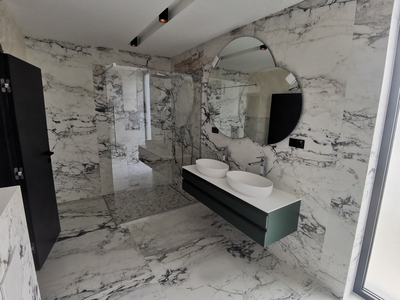 Modernt badrum med högkvalitativa marmorelement och dubbla handfat