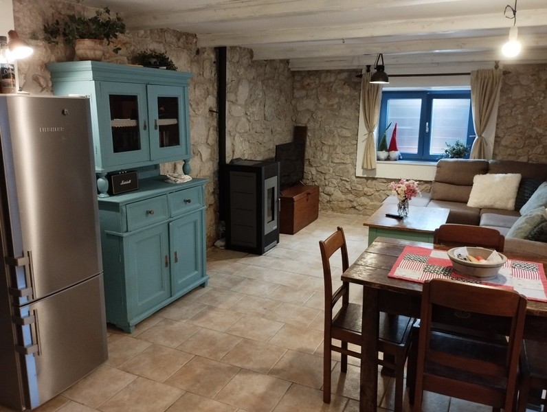 Öppen vardagsrumsdel med matplats och traditionella möbler, perfekt för att köpa ett hus i Kroatien.