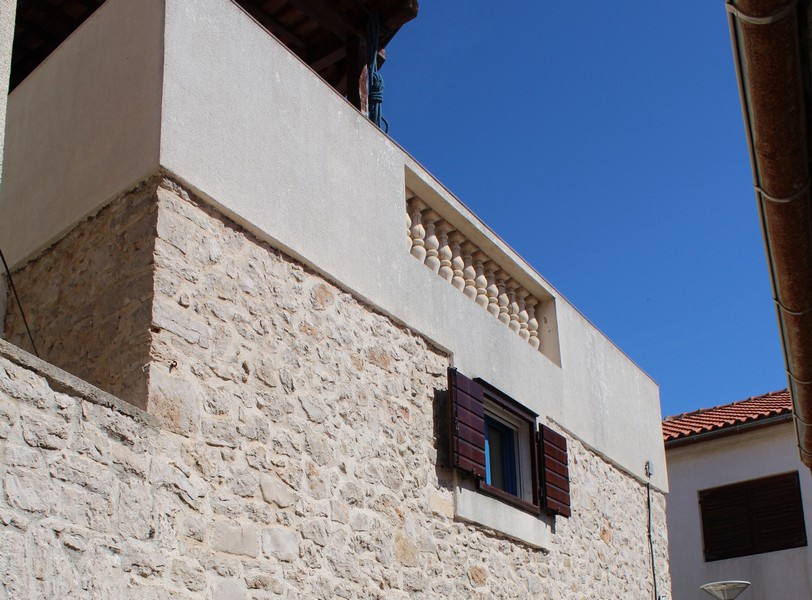 Den övre fasaden på ett traditionellt stenhus i Betina, perfekt för dem som vill köpa ett hus i Kroatien.