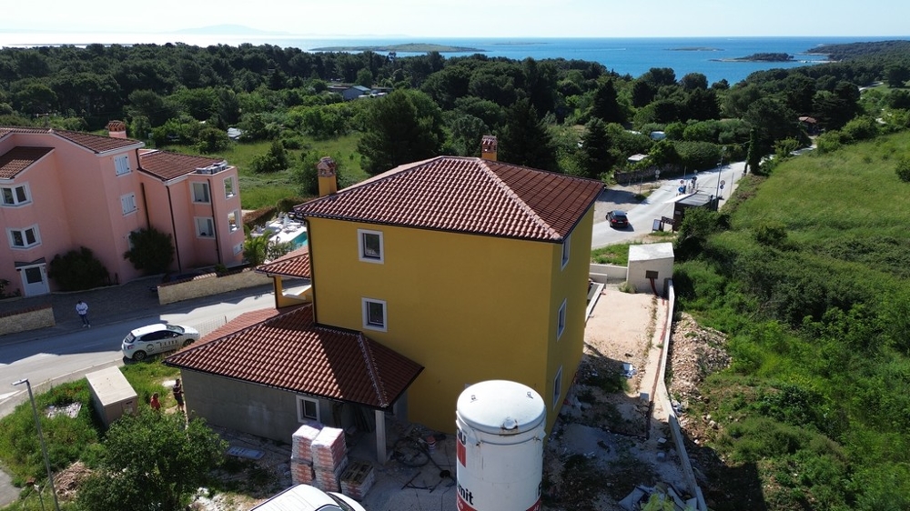 Villa i Kroatien under uppbyggnad med utsikt över det omgivande kustlandskapet och grönområdena