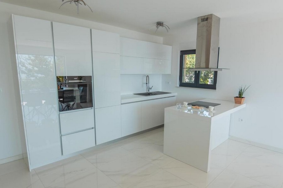 Modernt kök med vita skåp och en central ö