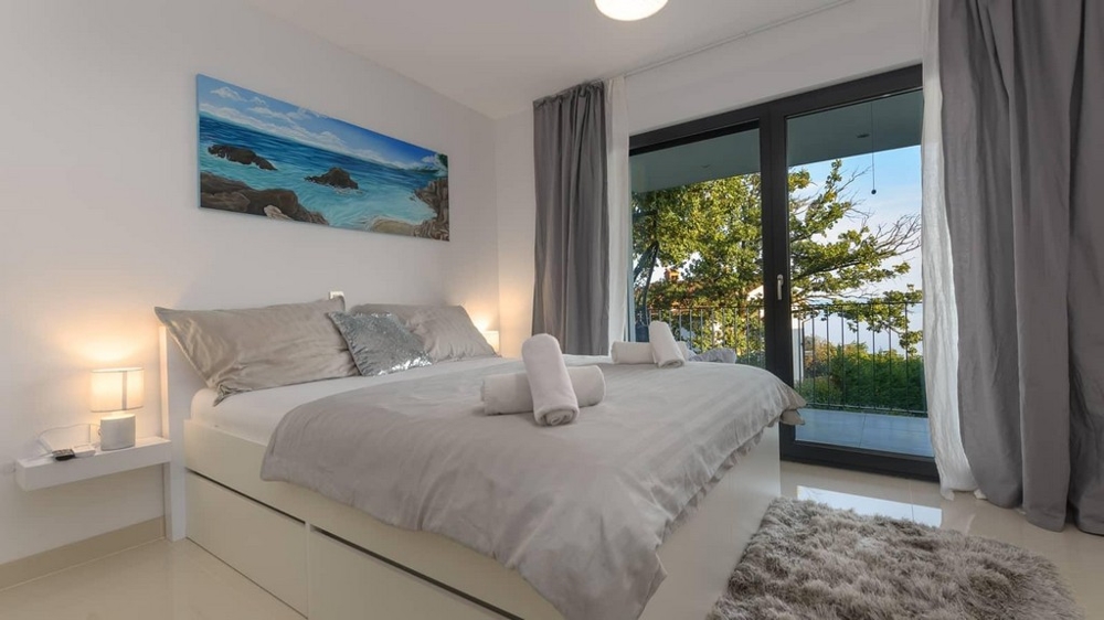 Mysigt sovrum med balkong och utsikt över lummig grönska