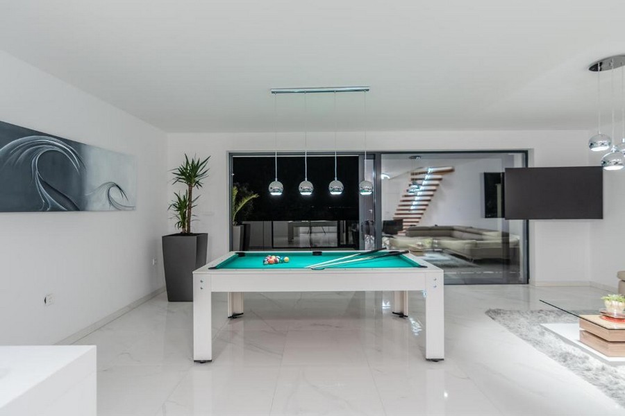 Fritidsrum med biljardbord och snygga belysningsarmaturer