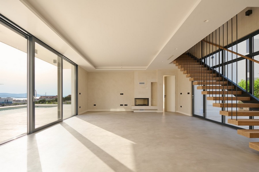 Ljust vardagsrum i villa i Kroatien med öppen spis och stora fönster, till salu