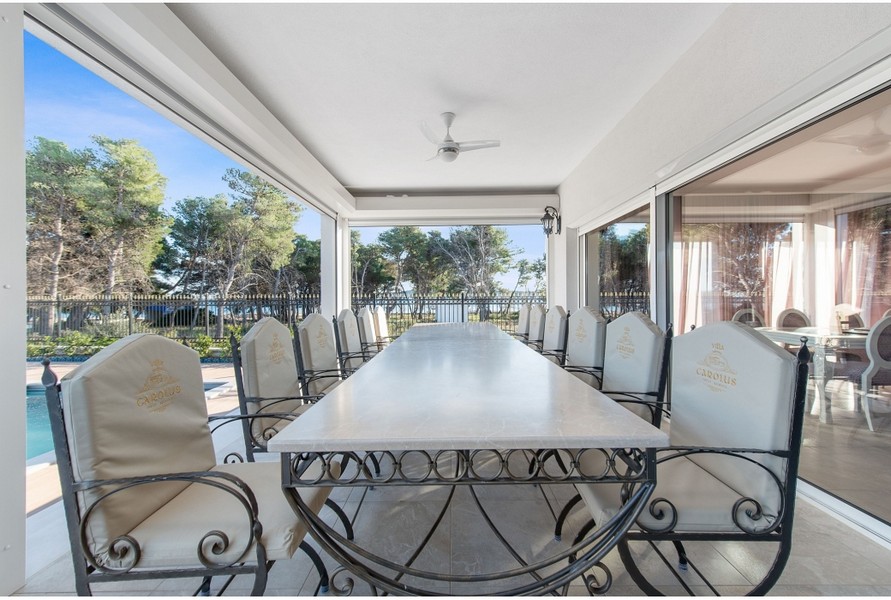 Täckt matplats i Villa H3042 med ett stort bord och snygga stolar