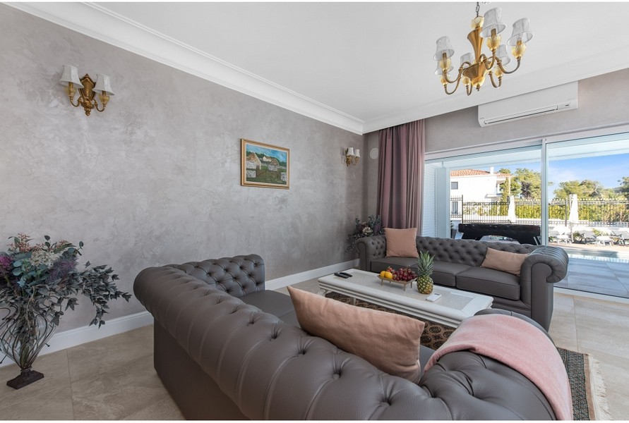 Elegant vardagsrum i Villa H3042 med bekväma soffor och utsikt över uteplatsen
