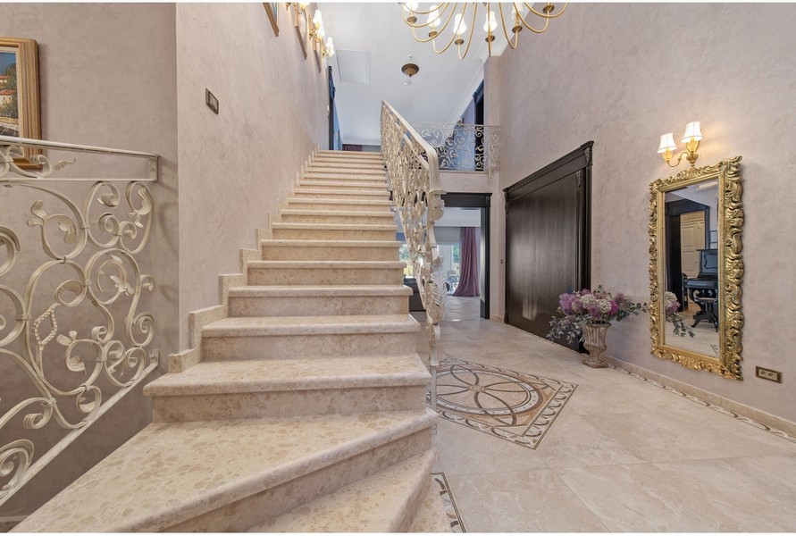 Rymlig hall i Villa H3042 med en utsmyckad trappa och eleganta dekorationer