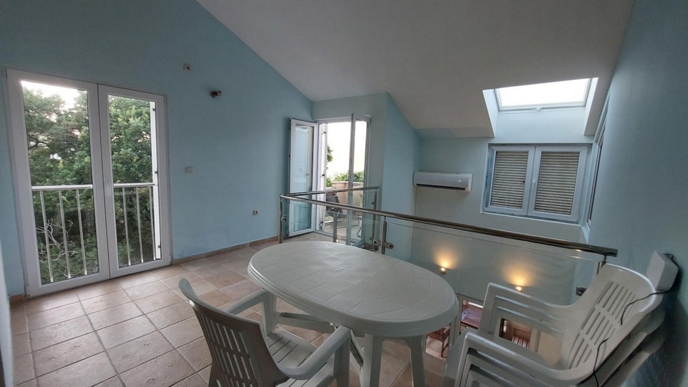 Galleri med bord, stolar och tillgång till två balkonger i ett hus i Kroatien