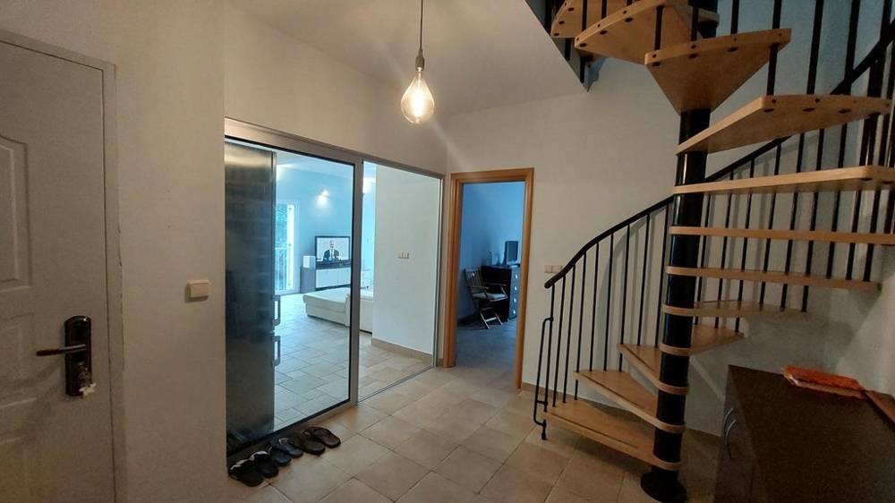 Entré med spiraltrappa och utsikt in i vardagsrummet i ett hus i Kroatien