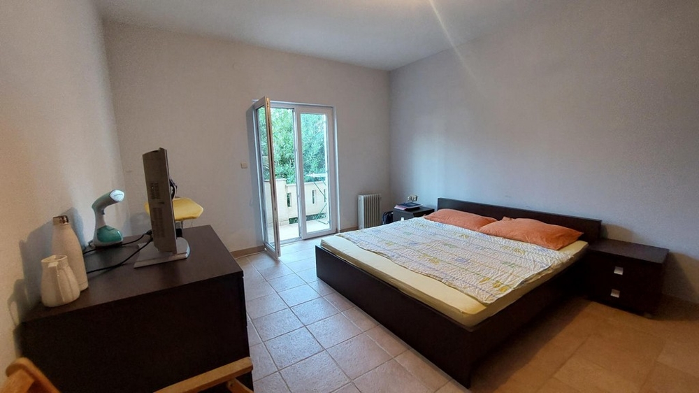 Sovrum med dubbelsäng och tillgång till balkong i ett hus i Kroatien