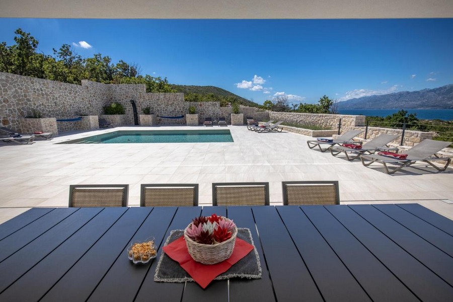 Terrass med pool och solstolar