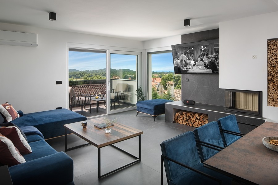 Modernt vardagsrum med högkvalitativ öppen spis och havsutsikt.