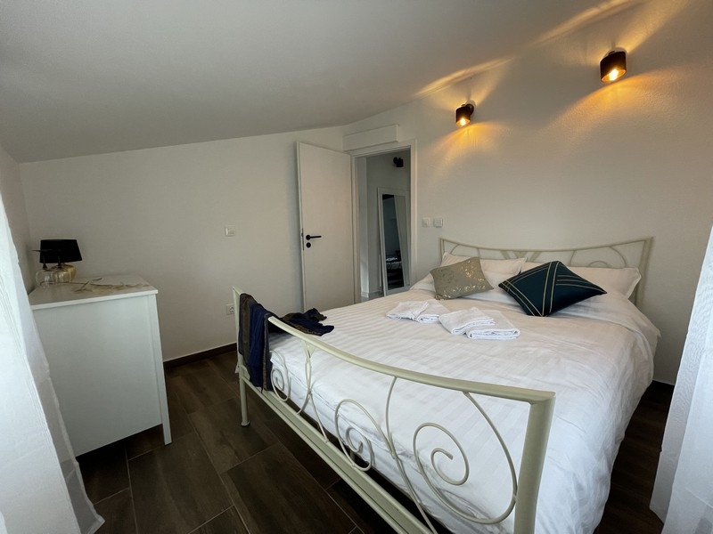 Sovrum med vit smidesjärnsäng, dekorativa kuddar och modern atmosfär