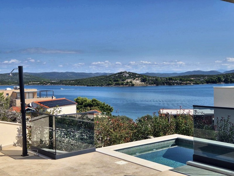 Skalkonstruktionsrum med golvvärme och två fönster, utsikt över grönt landskap