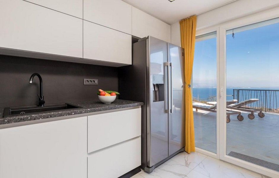 Modernt kök med havsutsikt och gula gardiner