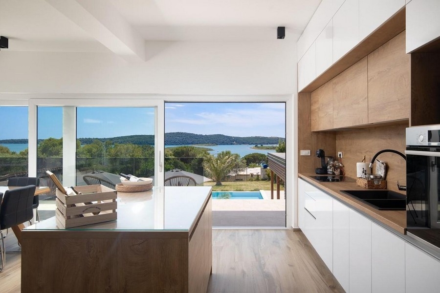Modernt kök med utsikt över poolen och havet.