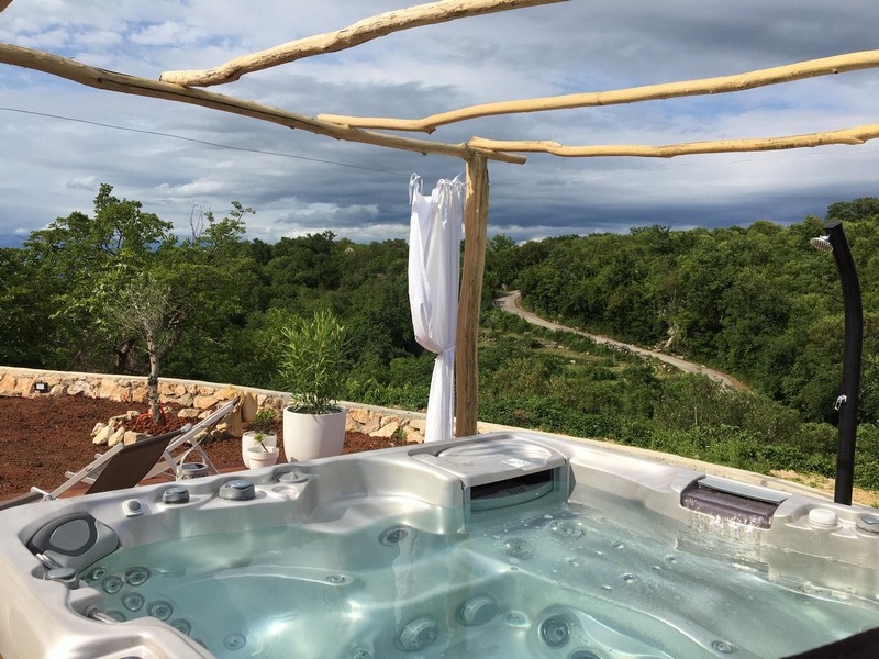 Jacuzzi och utsikt över grönskan från terrassen till hus H3415, som är till salu på Krk.