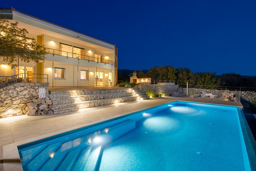 Villa H3417 tagen från poolen på natten.
