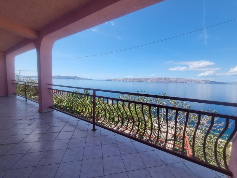 Rymlig terrass med havsutsikt med böjda räcken, under en täckt yta.