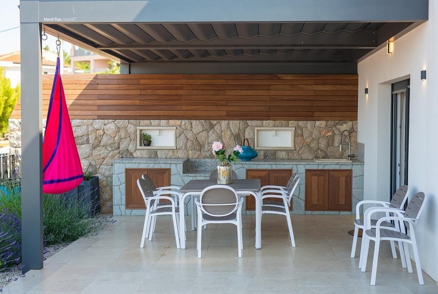 Utematplats och stenkök i dagsljus, med hängmatta