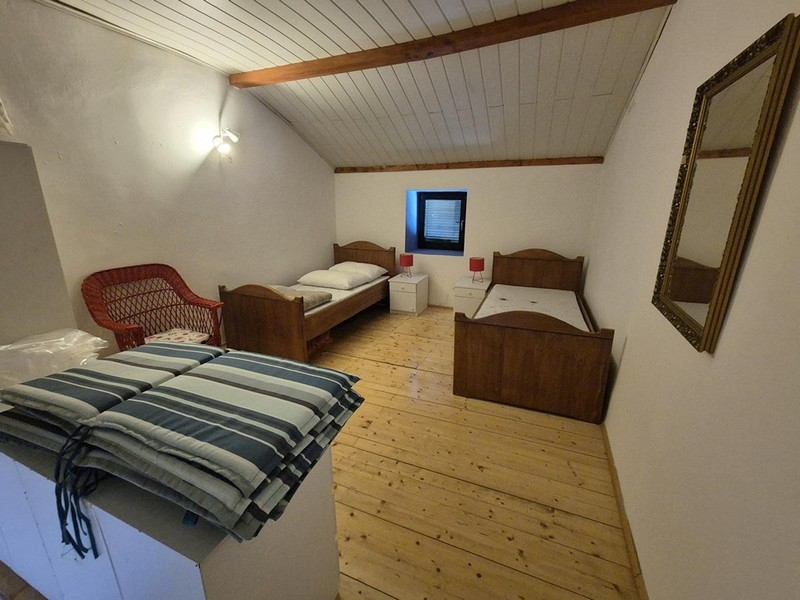 Sovrum med två enkelsängar och enkel inredning.