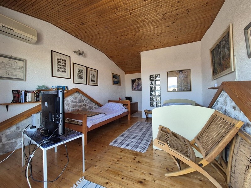 Övervåning med säng, trämöbler och bilder