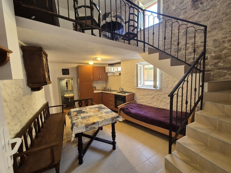 Vardagsrum i rustik stil med träbjälkar och stentrappor.