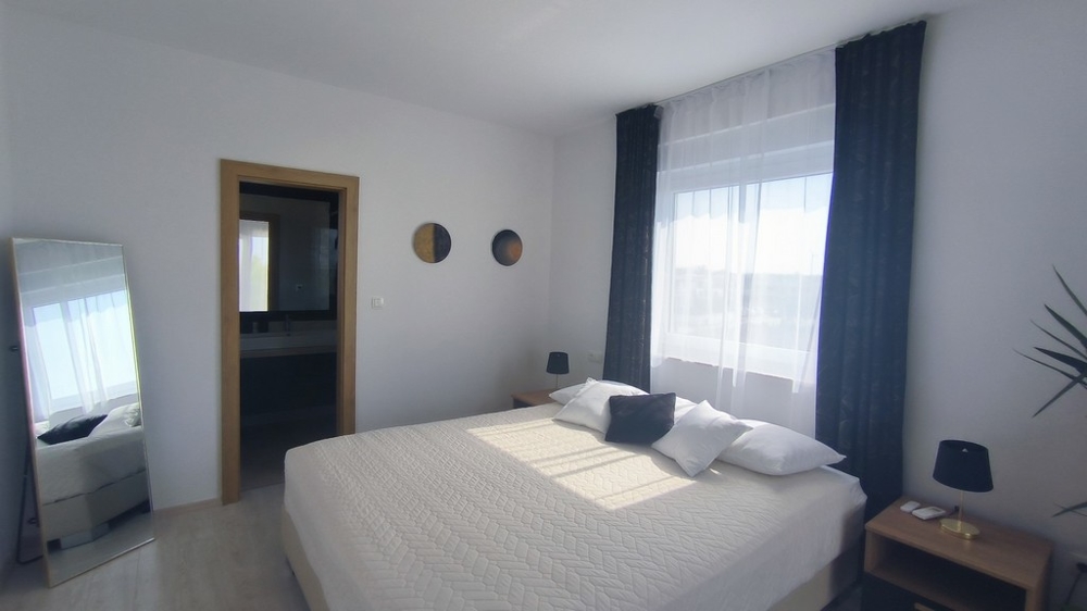 Andra sovrummet med stor säng och angränsande badrum.