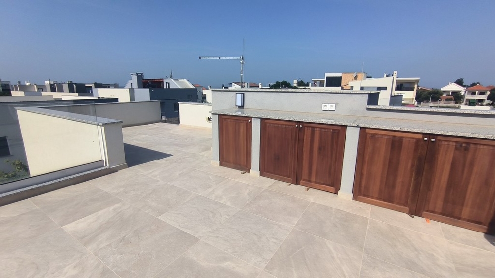 Rymlig takterrass med inbyggda trämöbler.