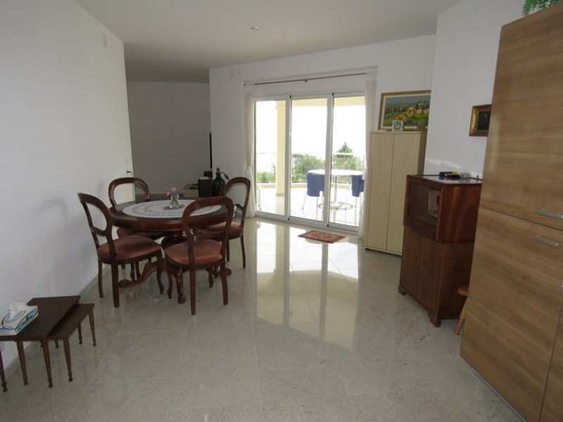 Matplats med runt bord och tillgång till terrassen med havsutsikt.