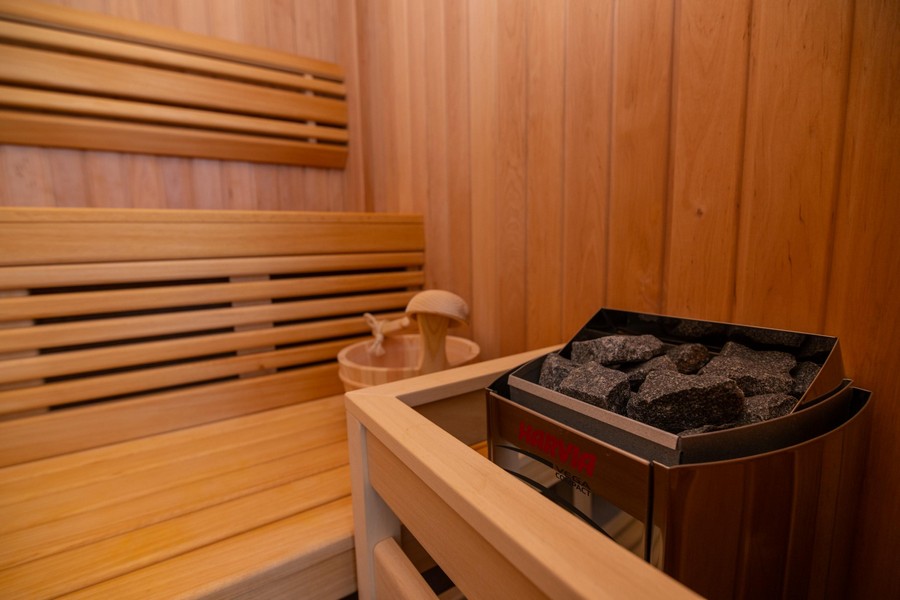 Bastu med träpanel och öppen spis i sten