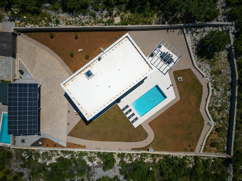 Ovanifrån av fastigheten med villa, pool och trädgård