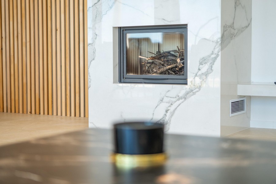 Öppen spis med modern marmordekoration i vardagsrummet